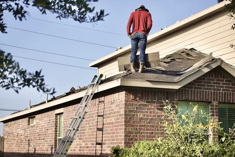 Professional roofer working on a residential roof in Garden Oaks